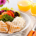 Pessoa preparando uma refeição saudável com alimentos nutritivos para apoiar os treinos. Uma alimentação equilibrada ajuda a fornecer energia, favorecer a recuperação muscular e melhorar o desempenho físico durante as atividades.