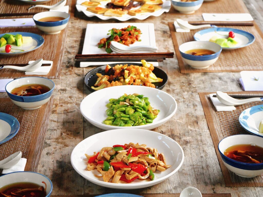 Mesa com diversos alimentos saudáveis servidos em pratos, representando uma alimentação equilibrada e rica em nutrientes.