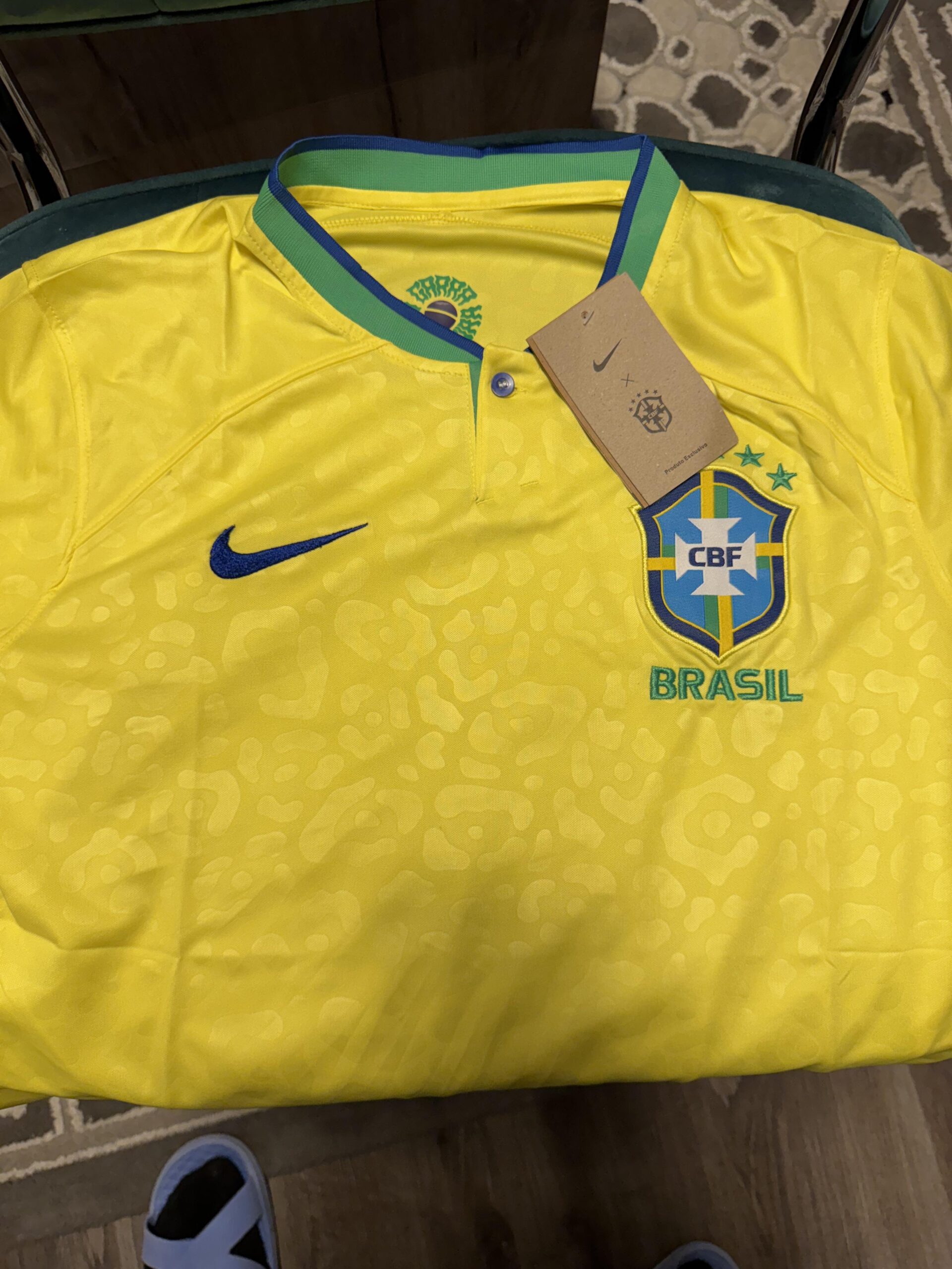 Camisas de futebol, álbuns de figurinhas e produtos da Copa do Mundo 2026 expostos em lojas e centros comerciais brasileiros, destacando a diferença entre itens oficiais e produtos falsificados encontrados no comércio popular.